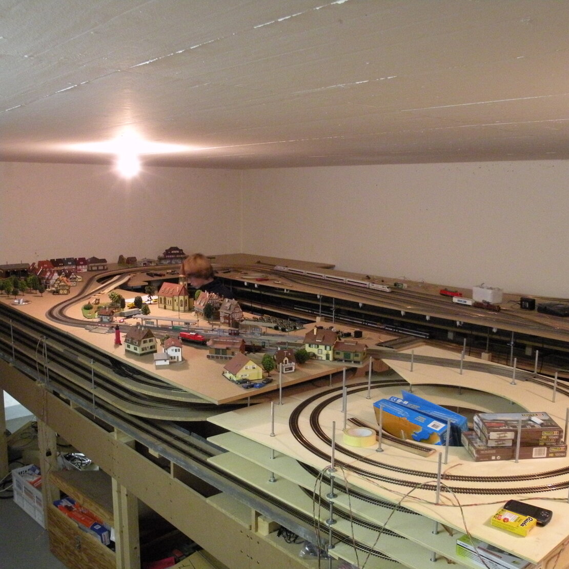 Detailreicher Modelleisenbahn-Landschaftsausschnitt mit Gleisen